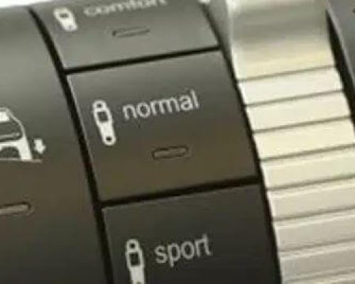Primer plano del selector de modo de conducción de un automóvil que muestra los botones para los modos "confort", "normal" y "deportivo".