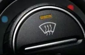 Primer plano del botón del desempañador de la ventana trasera de un automóvil, con un símbolo de líneas onduladas.