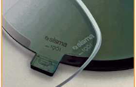 Primer plano de dos lentes de gafas con la marca "sisma" y números de serie visibles, colocadas sobre una superficie oscura.