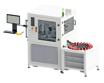 Máquina industrial automatizada con zona de procesamiento cerrada, mesa giratoria con soportes rojos y estación de trabajo informática lateral sobre fondo blanco.