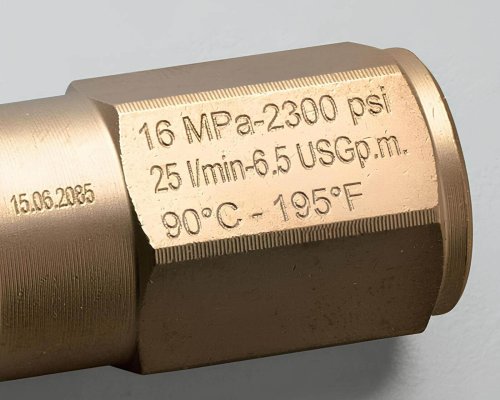 Primer plano de un accesorio metálico grabado con especificaciones: 16 MPa, 2300 psi, 25 l/min, 6,5 USGpm, 90°C a 195°F, y una marca de fecha del 15.06.2025.