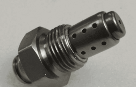 Un limitador de aceite de metal con una base roscada y múltiples orificios en el cuerpo cilíndrico, a menudo utilizado después de la soldadura láser de precisión en la industria automotriz, se encuentra sobre una superficie blanca.