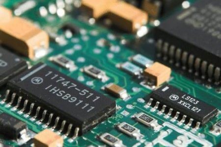 Scheda-elettronica Primer plano de una placa de circuito impreso verde con varios microchips, resistencias y componentes electrónicos.
