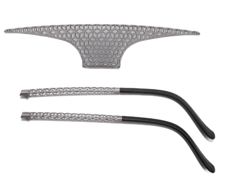 Se muestran dos patillas de gafas geométricas metálicas y un puente nasal a juego, con un patrón tipo panal en el puente y un diseño recto en las patillas.