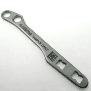 Un soporte metálico alargado con el texto "sisima SAMPLE ONLY" y un código QR, con orificios en ambos extremos, se muestra sobre un fondo liso.