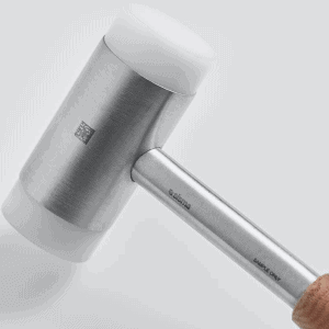 Un mazo plateado con una cabeza de goma blanca y un mango de madera sobre un fondo gris claro.