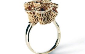 Anillo de oro con un diseño intrincado y poroso que forma una parte superior escultórica.