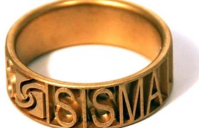 Un anillo de oro con la palabra "SISMA" grabada a lo largo de la banda.