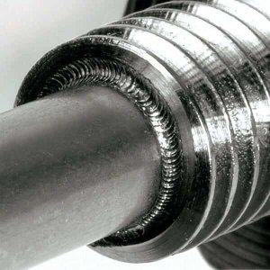 Primer plano de una varilla de metal con un patrón en espiral texturizado alrededor de su sección superior, que muestra una artesanía detallada y un brillo metálico.