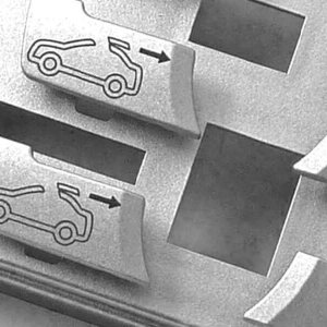 Primer plano de los botones del símbolo del automóvil con flechas, que indican funciones relacionadas con la apertura o el cierre de puertas o baúles del automóvil.