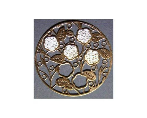 Intrincado diseño circular de metal con patrones florales y de hojas sobre un fondo oscuro.