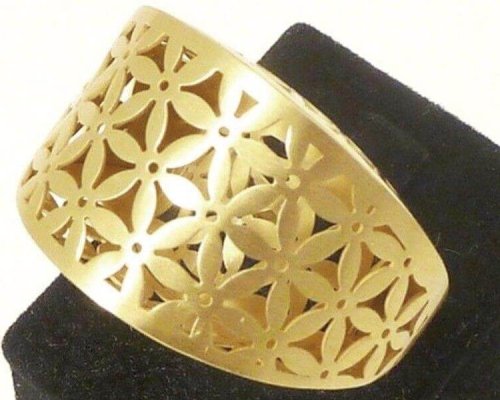 Pulsera de oro con diseño floral recortado, exhibida sobre un soporte negro.