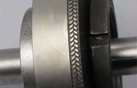 Primer plano de componentes industriales metálicos con bordes texturizados y secciones roscadas, que muestran signos de desgaste y uso.