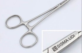 Primer plano de una pinza quirúrgica metálica con la etiqueta "SISMA UDI" en el mango. El recuadro muestra una vista detallada de la etiqueta y un código QR.