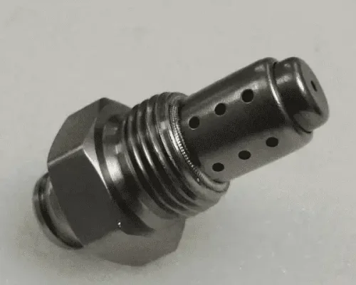 Primer plano de un componente mecánico metálico con base roscada y múltiples orificios pequeños en la parte superior cilíndrica.