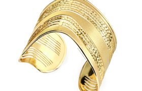 Pulsera de oro con diseño en la parte posterior abierta que presenta patrones texturizados paralelos y secciones suaves.