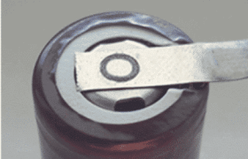 Una herramienta de metal levanta la pestaña de la parte superior de una lata de aluminio sellada, lista para abrirla.